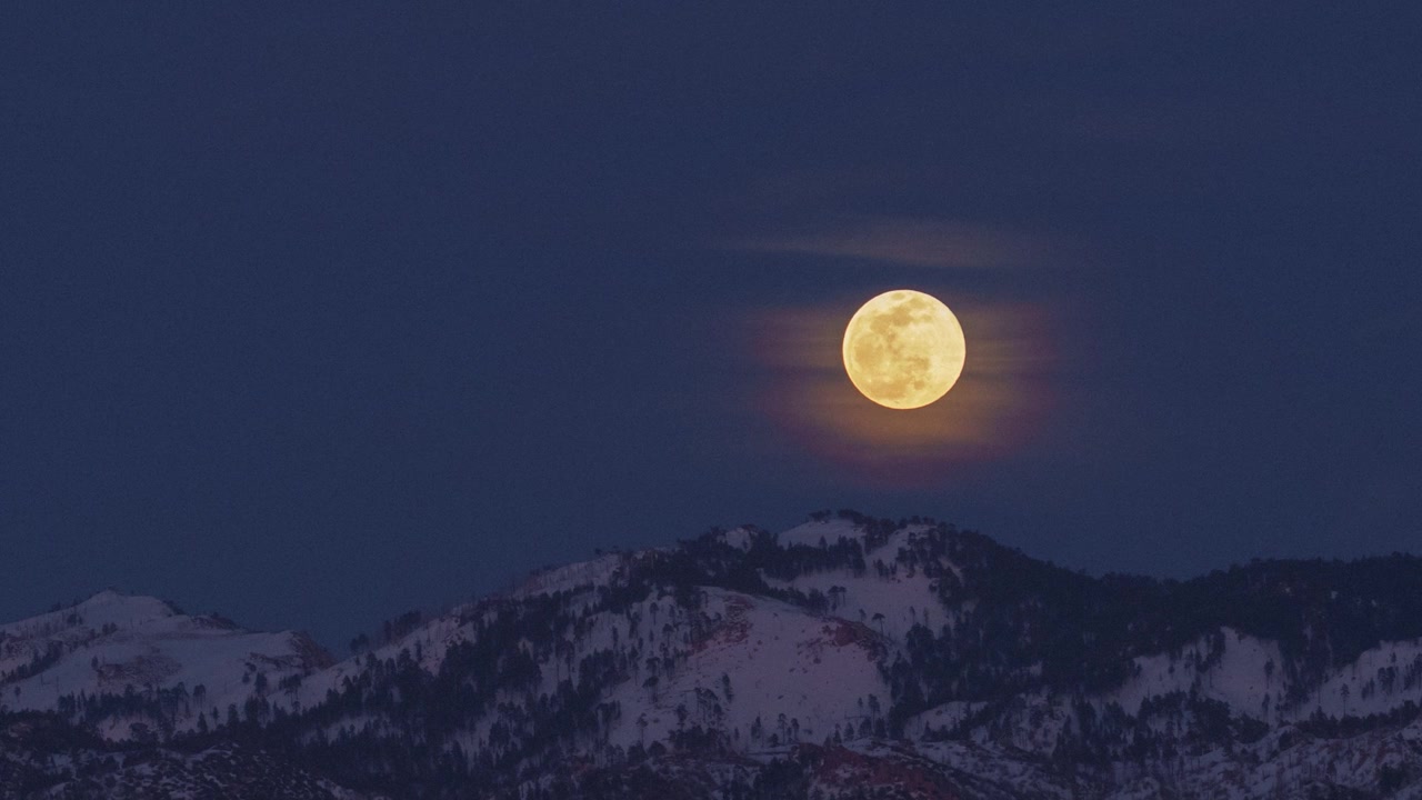 Time-lapse da lua cheia nascendo sobre picos de montanhas nevados, Floresta Nacional de San Bernardino, Califórnia, filmado do Lago Arrowhead, Califórnia.