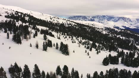 Toma-Aérea-De-Un-Esquiador-Esquiando-En-Una-Pista-Nevada-Vacía-Durante-El-Covid-19-Y-En-El-Fondo-El-Pale-Di-San-Martino