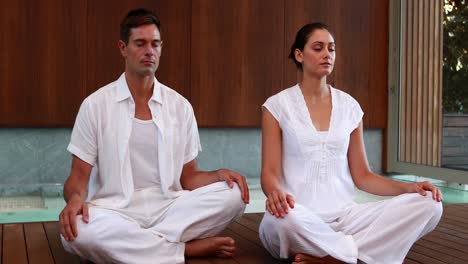 Calm-couple-in-white-sitting-in-lotus-pose