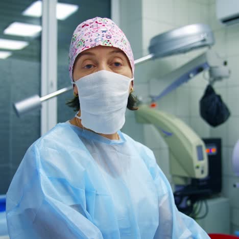 doctor in scrubs and facial mask tells methods of vision correction to the camera. modern clinic background