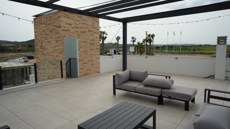 Ampia terrazza panoramica moderna con mobili da salotto per esterni, design pulito e layout aperto. Ideale per il relax, spazio sociale o uno stile di vita immobiliare di lusso in un ambiente dal clima caldo.