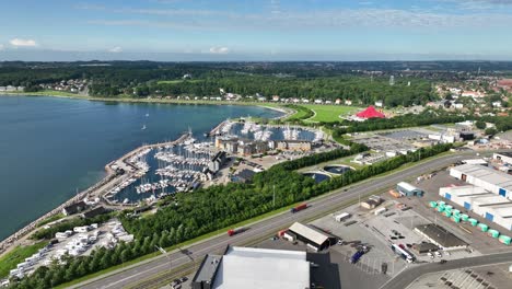 Marina-for-sailing-vessels-and-private-boats-in-Aarhus-Denmark---Marselisborg-beach-seen-in-background---Summer-aerial