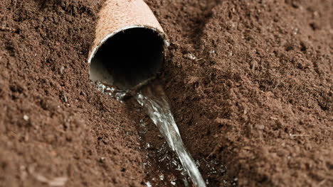 water flowing through a pipe in the soil