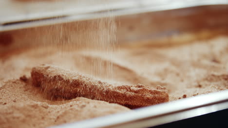 Überzug-Churros-Mit-Zucker-Und-Zimt-Mit-Metallzange-In-Festival-Stand