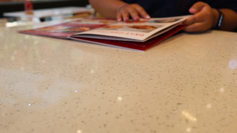 persona hojeando un menú en una mesa