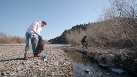 teamwork cleaning plastic on the beach. volunteers collect trash in a trash bag. plastic pollution and environmental problem concept. voluntary cleaning of nature from plastic. greening the planet