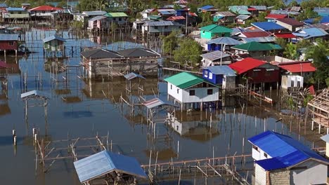 a fishing village made up of lots of small colourful buildings, all on stilts, on a calm lake