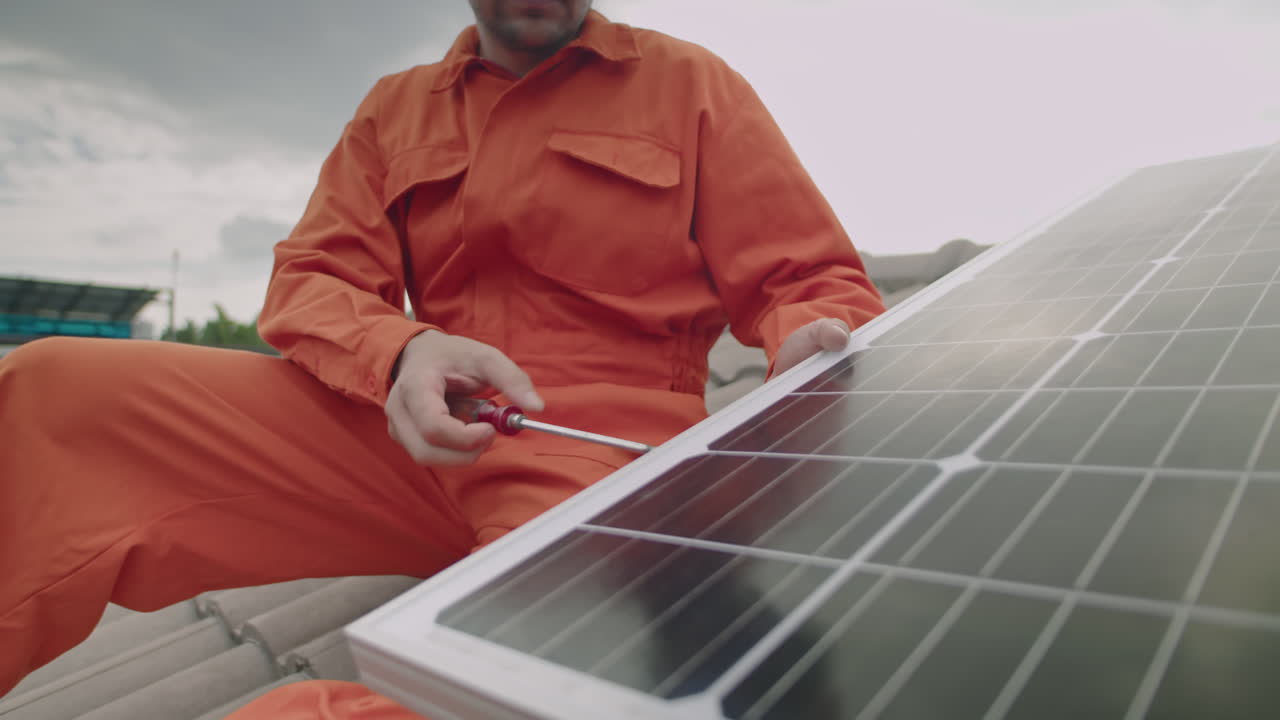 Technician Installing Solar Panel on Roof of House