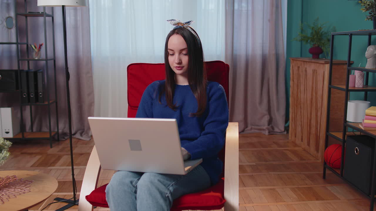 소파에 앉아 노란색 젊은 여성이 노트북 pc를 열고 집에서 거실에서 온라인으로 일을 시작합니다.