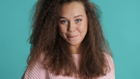 Caucasian-curly-haired-woman-smiling-to-the-camera.