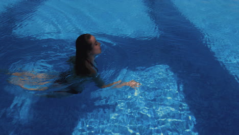 gorgeous woman swimming under water coming out happy slow motion