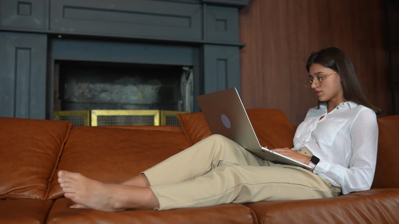mujer trabajando en una computadora portátil en un sofá en casa
