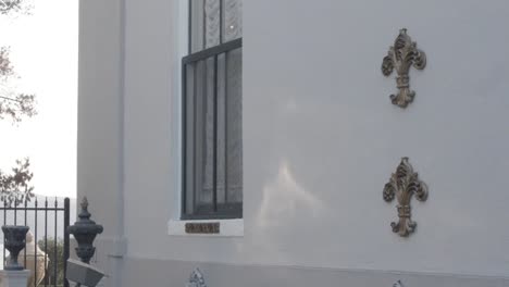 lateral external view of building, with focus on a window and some decoration in the wall