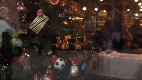 Weihnachtsbaum-Mit-Ornamenten-Zum-Verkauf,-Der-Sich-Durch-Das-Schaufenster-Auf-Dem-Festlichen-Weihnachtsmarkt-In-Straßburg,-Frankreich,-Europa-Dreht