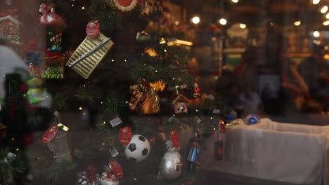 árbol de navidad con adornos para la venta girando a través de la ventana de la tienda en el festivo mercado de navidad en estrasburgo, francia europa