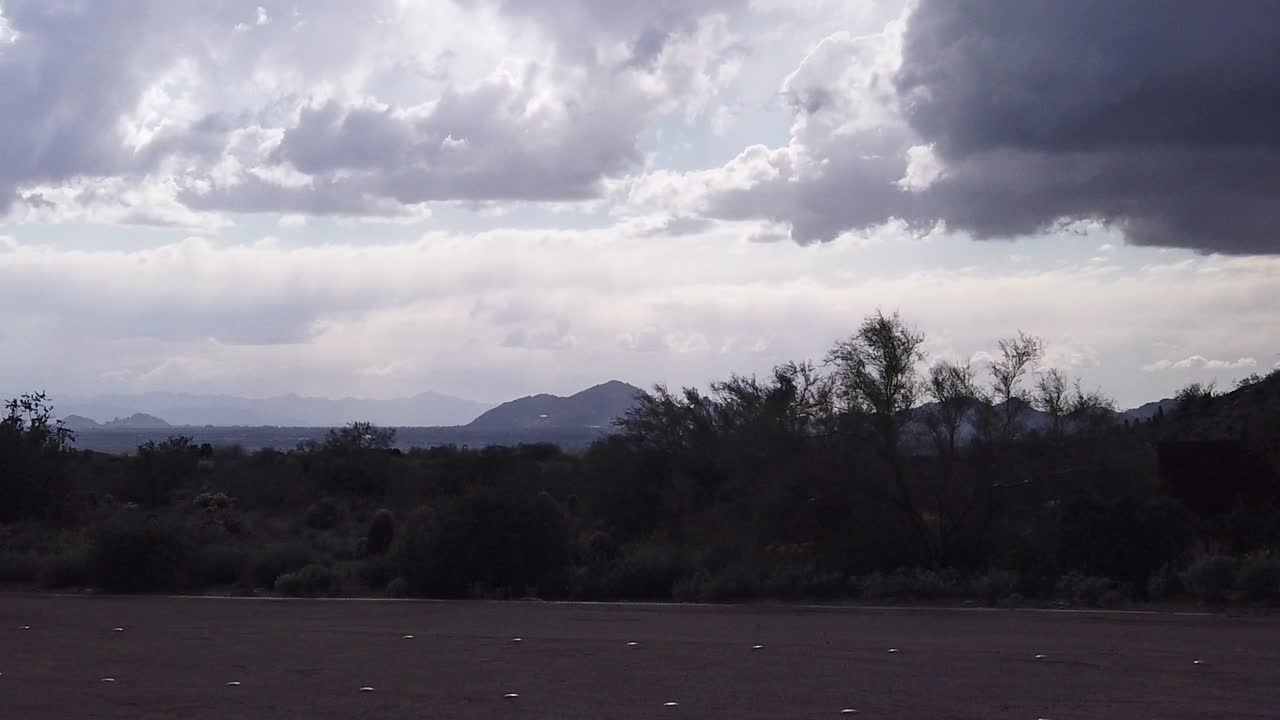 Pan across a darken sky and desert as the rain begins to fall, Lost Dog Wash Trailhead, Scottsdale, Arizona