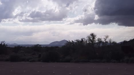 pan across a darken sky and desert as the rain begins to fall, lost dog wash trailhead, scottsdale, arizona