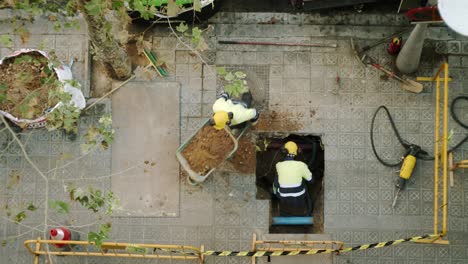 Vista-Superior-De-Los-Trabajadores-De-La-Construcción-Cavando,-Paleando-Y-Rompiendo-Un-Hormigón-En-Una-Calle-De-Barcelona