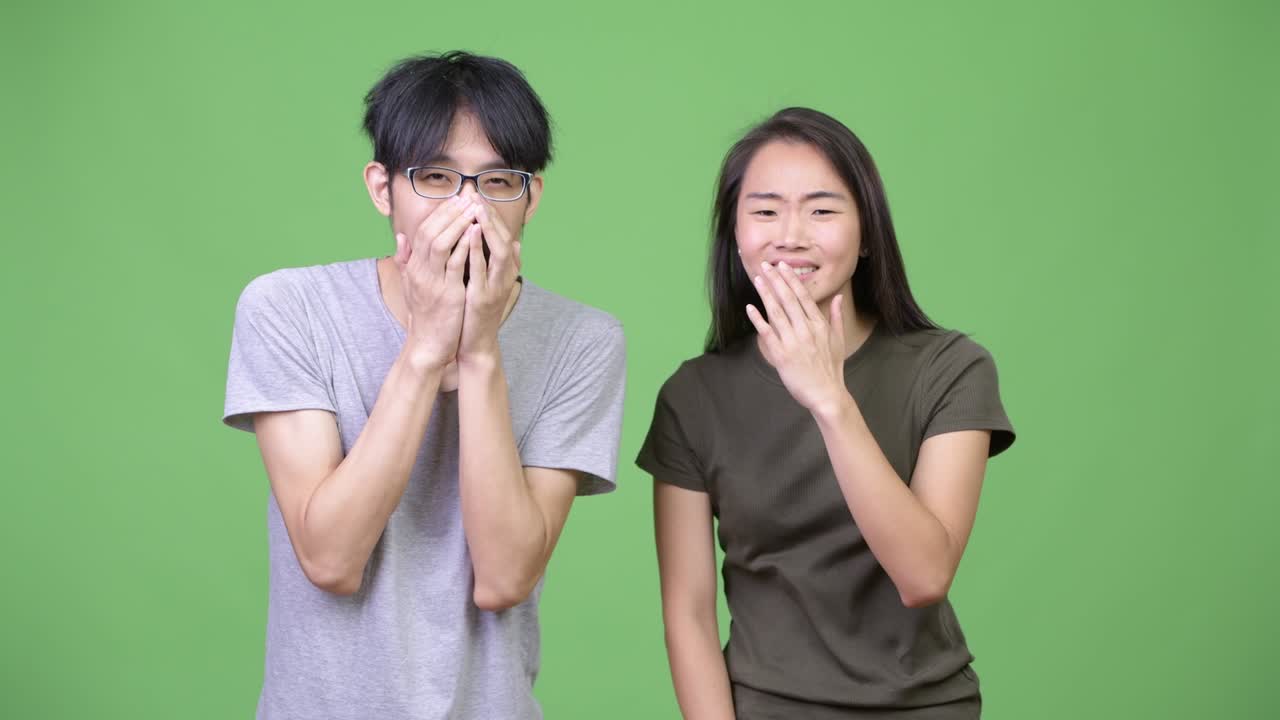 Young Asian couple looking shocked together