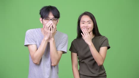 young asian couple looking shocked together