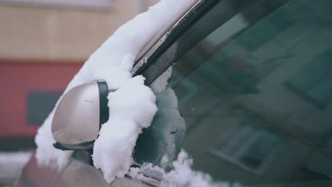 parked car with thick white snow layer after heavy snowfall