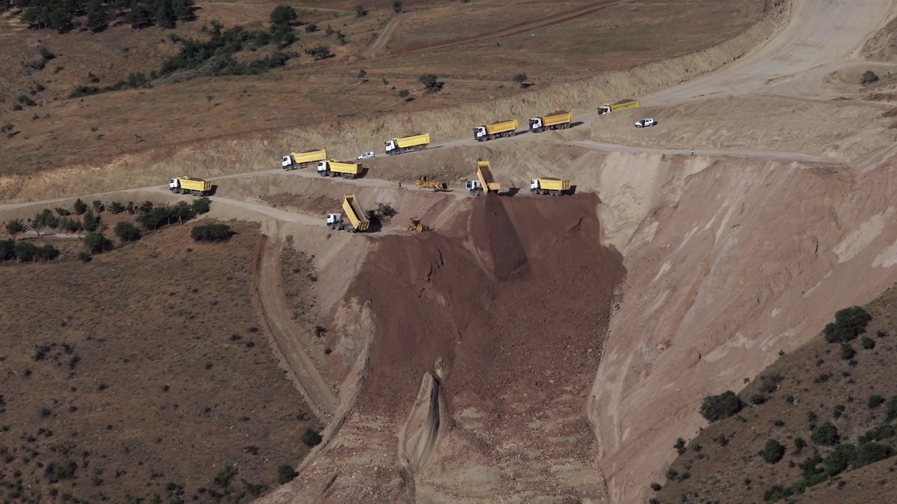 Yellow Dump Trucks Unloading Soil at a Construction Site