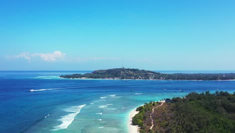 Olas-Blancas-Que-Hacen-Espuma-En-Una-Laguna-Turquesa-Poco-Profunda-Alrededor-De-Una-Isla-Tropical-Con-Bosques-De-árboles-En-Un-Cielo-Brillante-Al-Amanecer-En-Bali