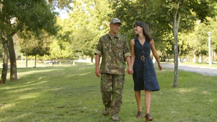Uomo militare felice in uniforme mimetica che abbraccia la fidanzata