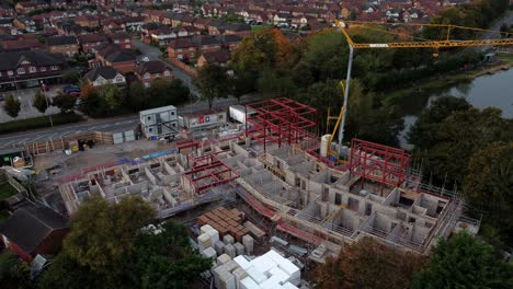 vista aérea edificio de grúa a orillas del agua desarrollo de la construcción de hogares de cuidado en el pueblo británico rural