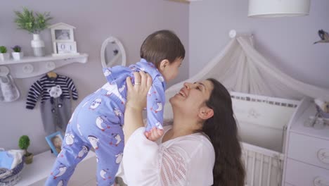 Mother-holding-her-baby-in-the-air.-Happy.