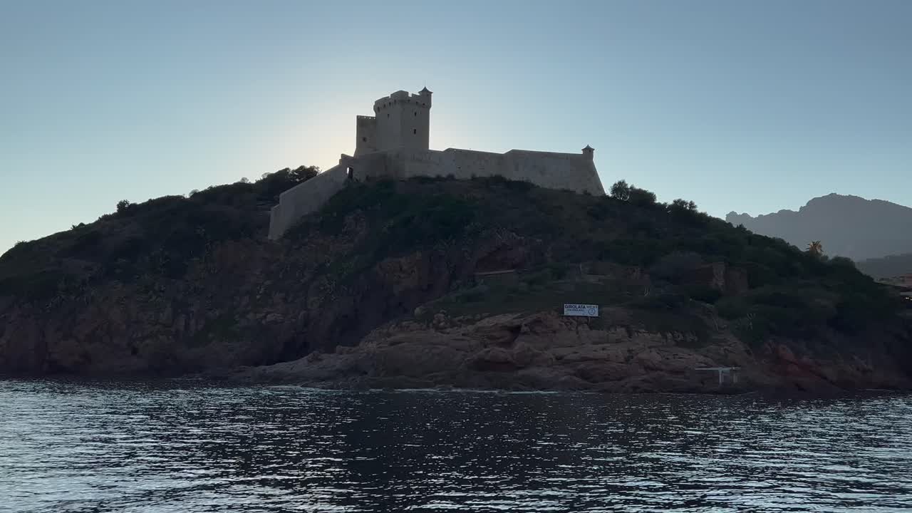 castillo de girolata y puerto al atardecer visto desde un velero que recorre la isla de córcega en francia