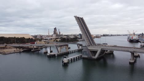 Aerial-view-of-an-open-drawbridge-allowing-a-ship-to-enter-an-industrial-port