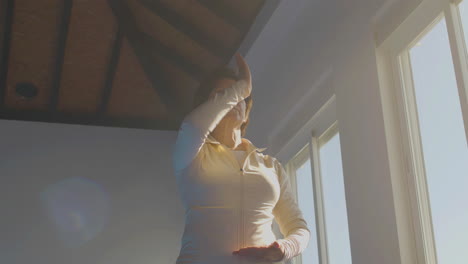 serious woman performing tai chi movements in gym