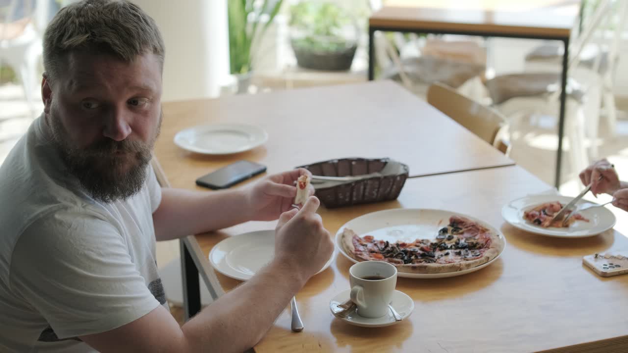 una pareja comiendo pizza en un restaurante.