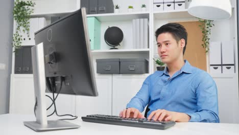 asian handsome business man using laptop computer working in office. attractive professional male employee worker sitting on table, feel happy and enjoy spending leisure time in corporate workplace.