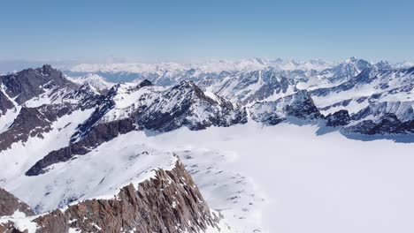 Wunderschöne-Filmische-Luftaufnahmen-Von-Schneebedeckten-Alpinen-Gletschergipfeln