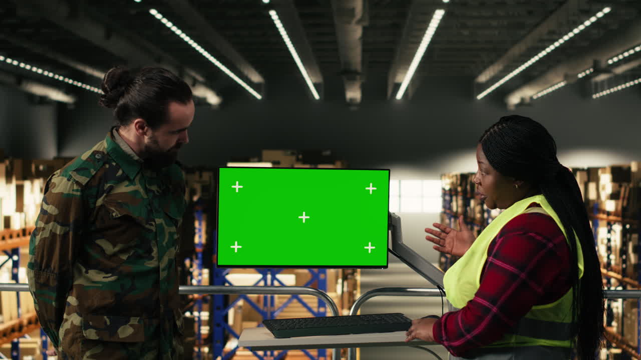 Diverse Warehouse Workers Discussing Logistics with Green Screen Monitor
