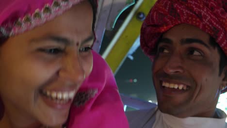 indian couple enjoying ferris wheel ride in traditional dresses at the pushkar mela, a carnival of rajasthan, india
