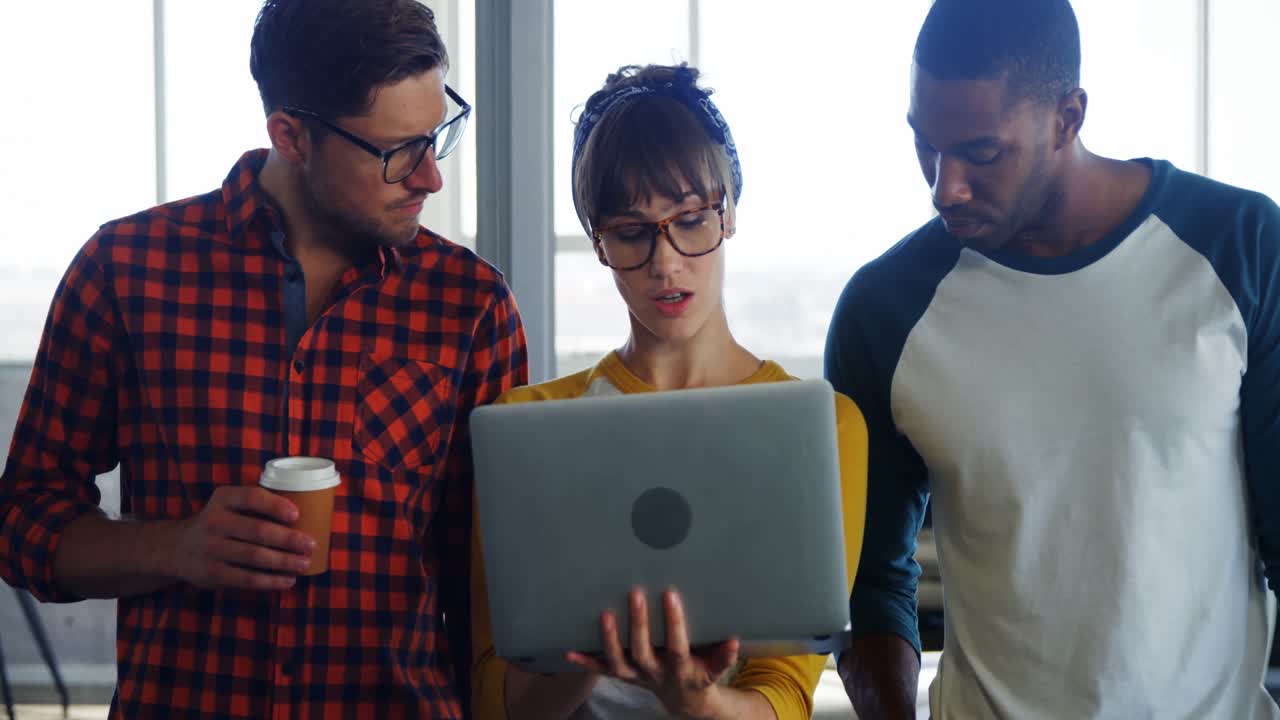 Business executives discussing over laptop