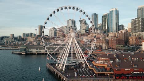 Die-Drohne-Erklimmt-Das-Riesenrad-Von-Seattle-Und-Schiebt-Sich-An-Der-Fahrbahn-Vorbei,-Um-Die-Ikonische-Skyline-Der-Stadt-Freizulegen