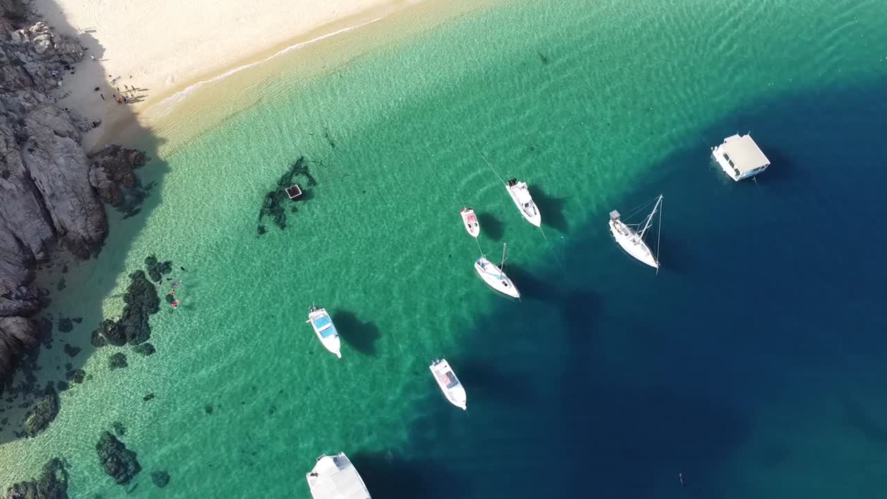 Aerial over Playa Balc&oacute;ncito with boats and yachts in green waters