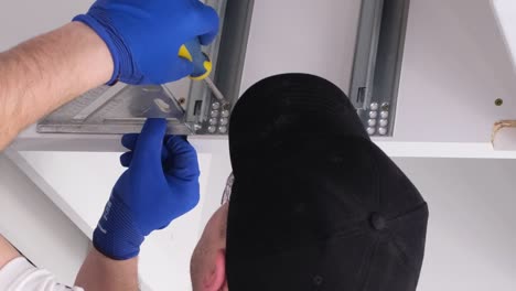 a professional master during the installation of kitchen furniture a professional master during the installation of kitchen furniture installation of modern highquality furniture accessories moving to a new apartment