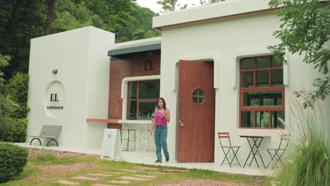 hermosa mujer tailandesa saliendo de un café de jardín moderno y contemporáneo en tailandia