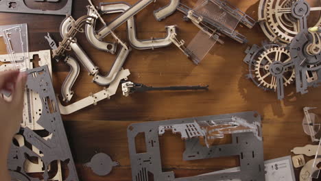 female hands assembling diy mechanical gears. overhead