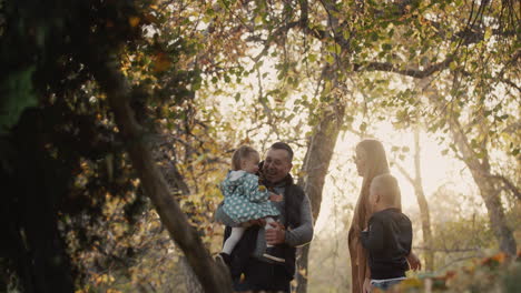 family with two children have fun in autumn park