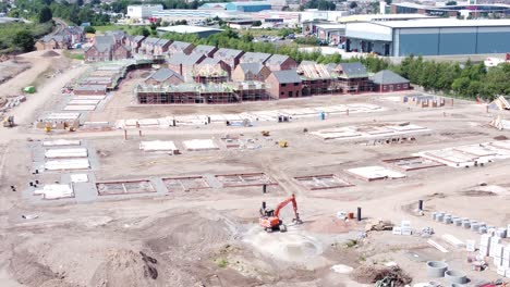 British-town-housing-development-working-foundation-construction-site-aerial-view-slow-pull-back-high-shot