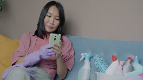 woman using phone while preparing for cleaning