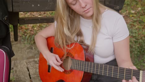 hermosa compositora y guitarrista practica por el bosque deseando bien