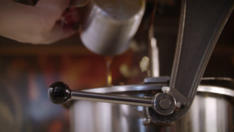 Worker-pouring-oil-in-popcorn-machine.-Preparing-for-popcorn-production