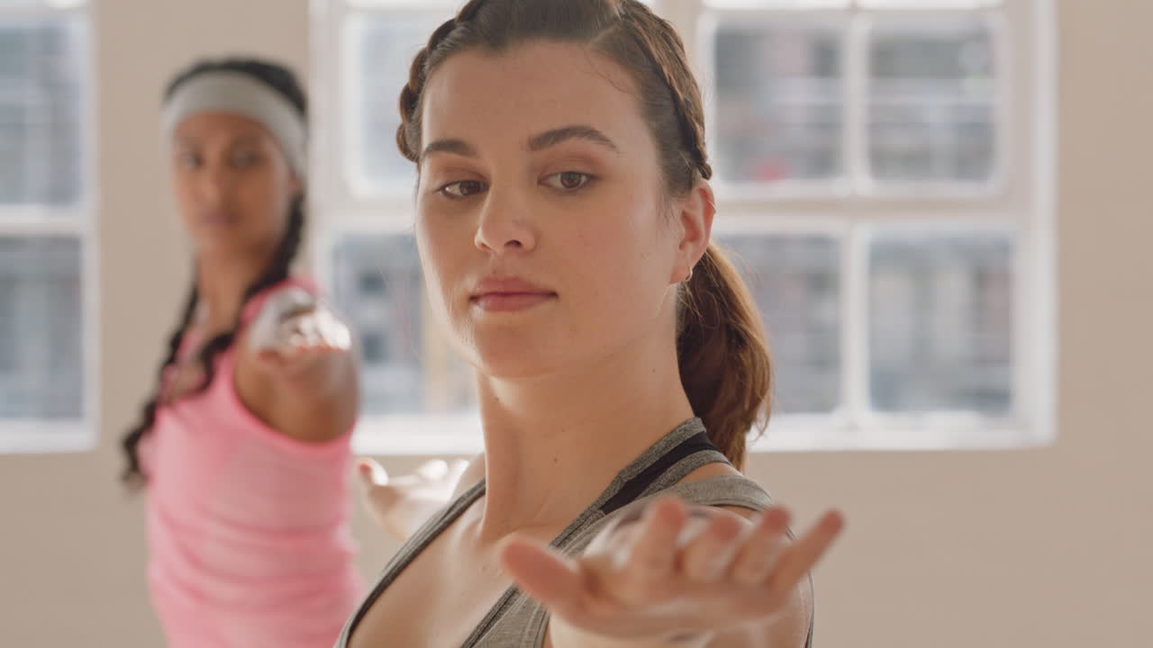 clase de yoga mujer caucásica saludable practicando pose guerrera disfrutando de un estilo de vida físico haciendo ejercicio con personas multiétnicas en un estudio de entrenamiento